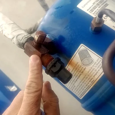Mão do técnico na válvula do reservatório durante o serviço